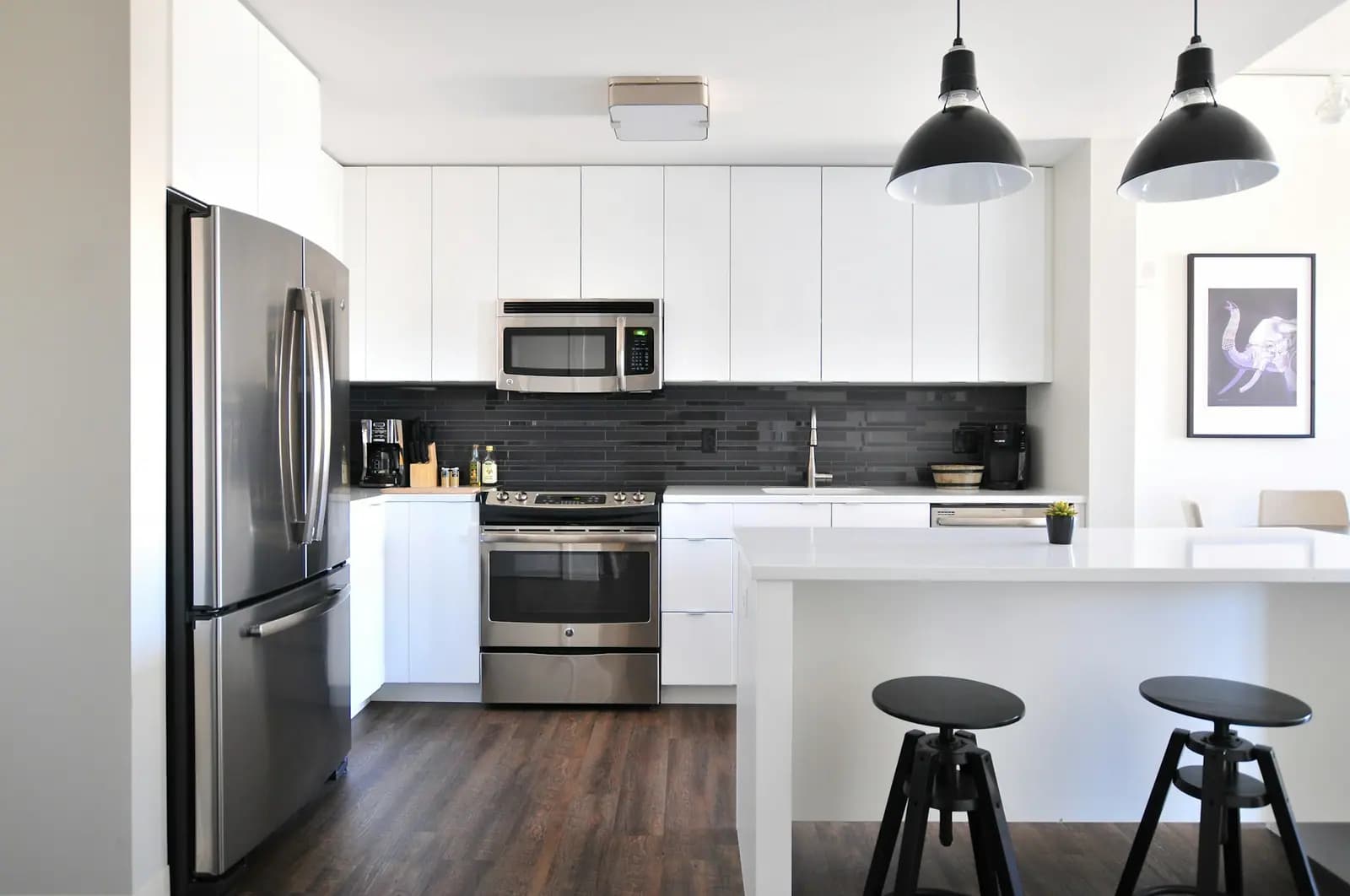 Kitchen with a stainless refrigerator, range, and over-the-range microwave beside a white island